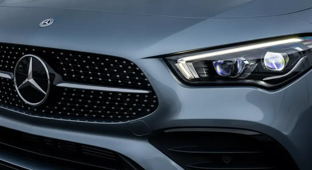 Close-up shot of the 2026 Mercedes-Benz CLA EQ Technology, highlighting illuminated grille, sharp LED DRL signature.